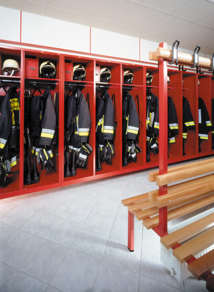 Zijaanzicht rode brandweerlockers in de kleedkamer